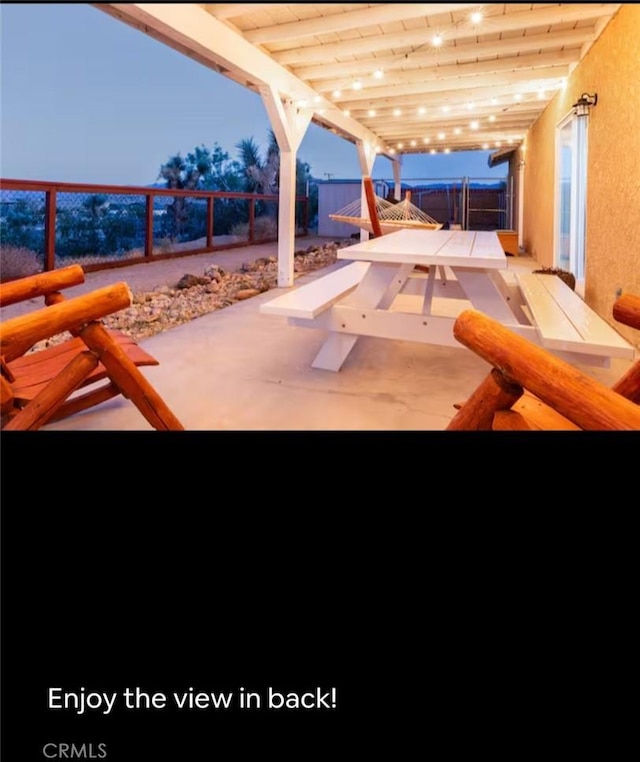 patio terrace at dusk featuring a fenced backyard