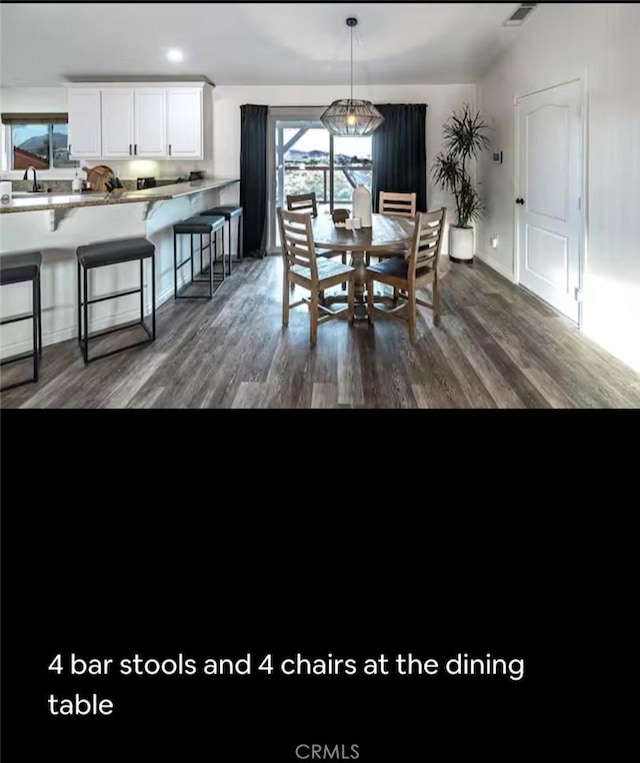 dining space featuring visible vents and dark wood finished floors