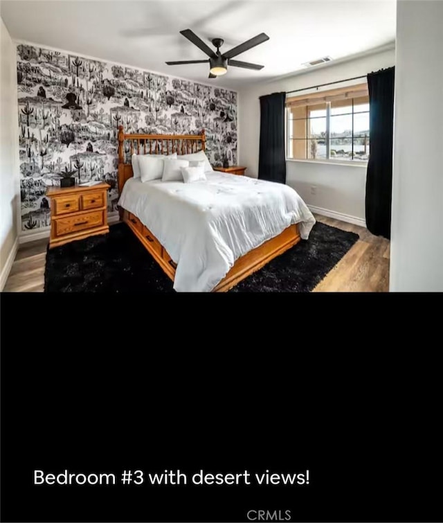 bedroom featuring visible vents, light wood-style floors, an accent wall, baseboards, and wallpapered walls