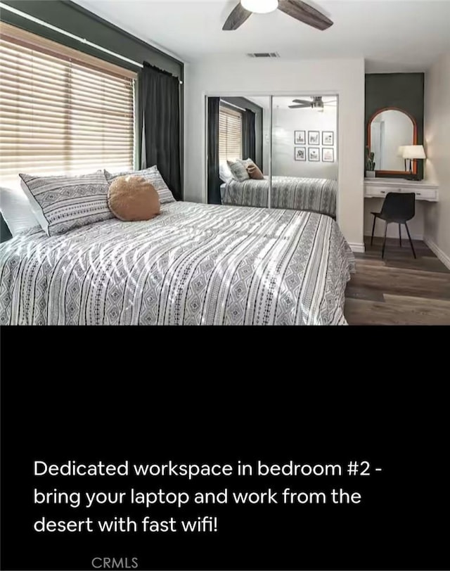 bedroom with wood finished floors, a closet, visible vents, and multiple windows