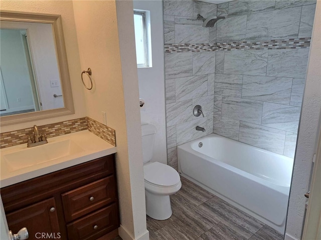 bathroom with tasteful backsplash, toilet, vanity, wood finished floors, and  shower combination