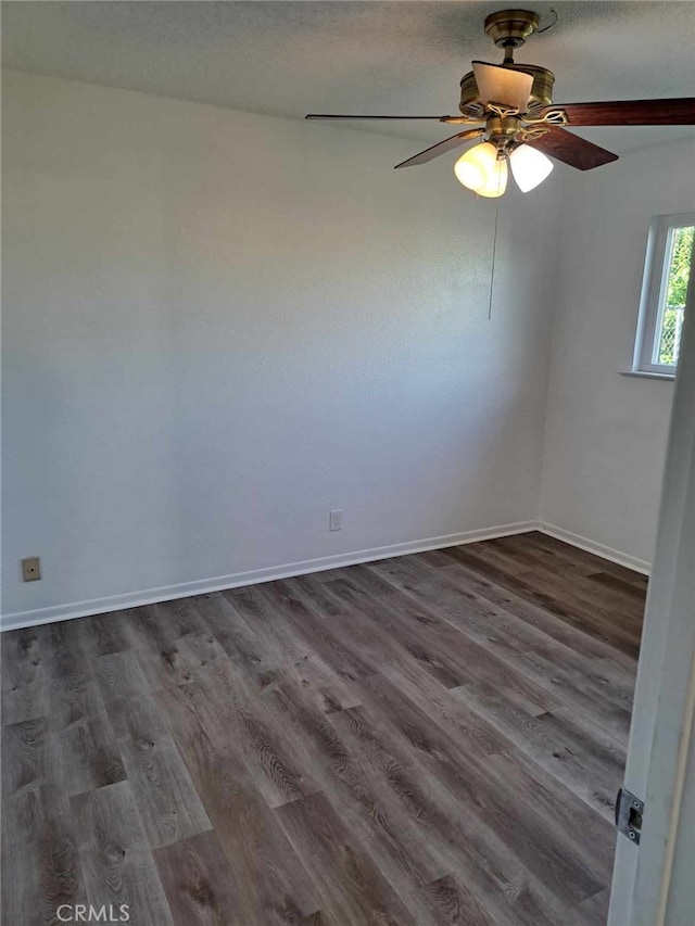 unfurnished room with ceiling fan, dark wood-style flooring, and baseboards