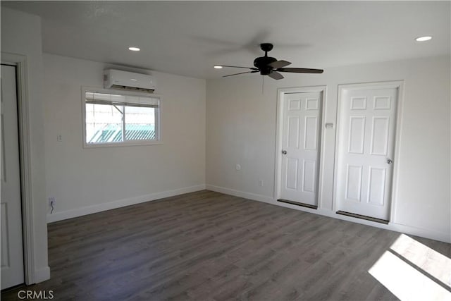 unfurnished bedroom with recessed lighting, a wall mounted AC, dark wood-type flooring, ceiling fan, and baseboards