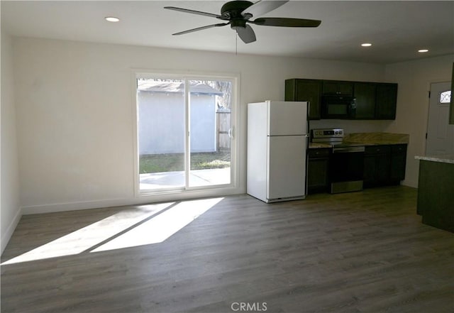 kitchen featuring dark wood-style flooring, stainless steel electric stove, light countertops, freestanding refrigerator, and black microwave