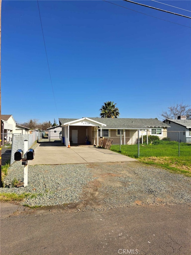 view of front facade featuring driveway, a garage, fence, and a front lawn