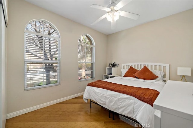 bedroom with wood finished floors, a ceiling fan, and baseboards