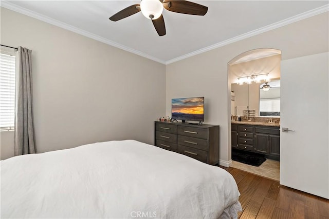 bedroom featuring ornamental molding, dark wood-type flooring, and arched walkways