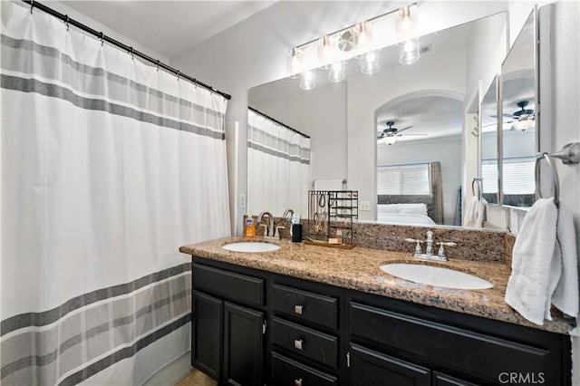 ensuite bathroom with ceiling fan, double vanity, a sink, and ensuite bathroom