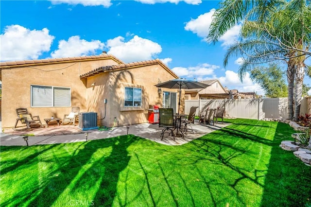 rear view of house featuring a fenced backyard, a yard, and stucco siding