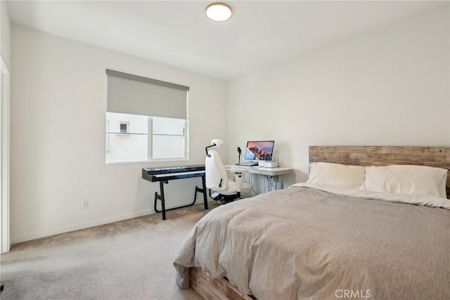 bedroom featuring light carpet and baseboards