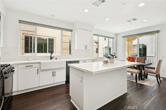 kitchen with dishwasher, light countertops, a center island, and black gas range oven