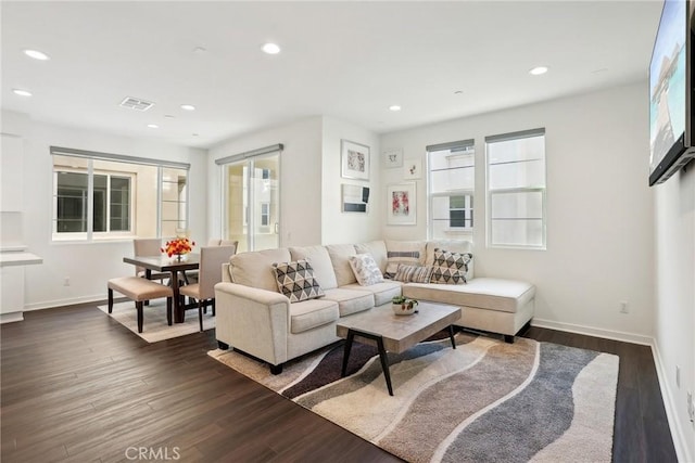 living room featuring dark wood-type flooring, recessed lighting, and visible vents