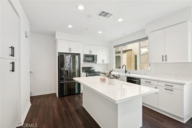 kitchen with stainless steel appliances, a center island, light countertops, and visible vents