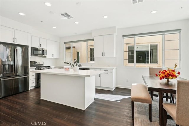 kitchen featuring a kitchen island, visible vents, white cabinets, light countertops, and appliances with stainless steel finishes