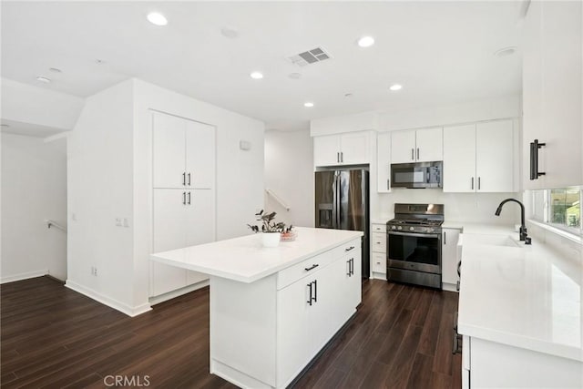 kitchen featuring light countertops, visible vents, appliances with stainless steel finishes, white cabinetry, and a kitchen island