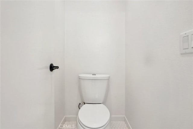 bathroom with baseboards and toilet