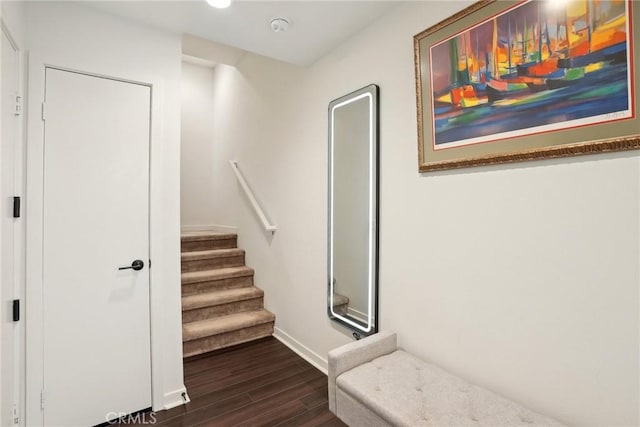 staircase featuring wood finished floors and baseboards