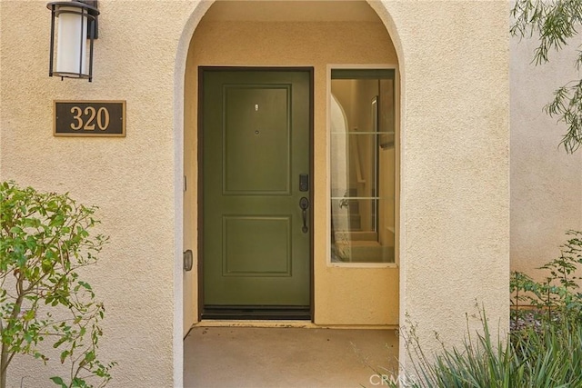 property entrance with stucco siding