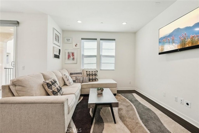 living room featuring baseboards, dark wood finished floors, and recessed lighting