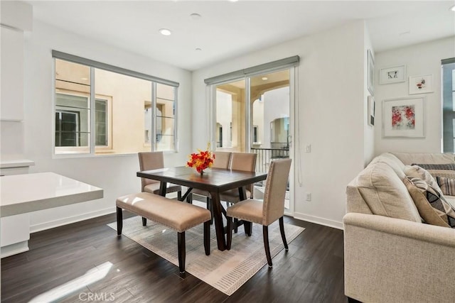 dining space featuring arched walkways, dark wood-type flooring, recessed lighting, and baseboards