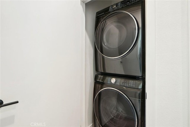 laundry area with stacked washer and dryer and laundry area