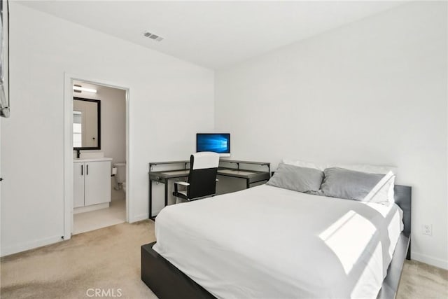 bedroom with light carpet, ensuite bath, visible vents, and baseboards