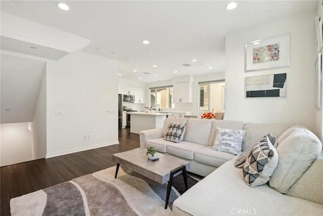 living room featuring recessed lighting, dark wood finished floors, and baseboards