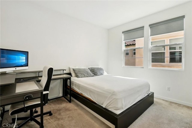 bedroom with light carpet and baseboards