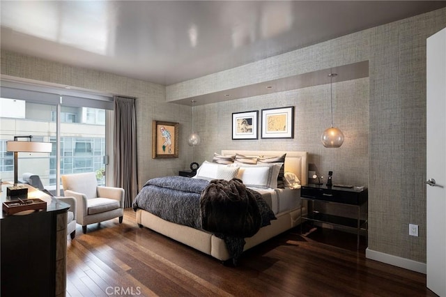 bedroom with dark wood-style floors, wallpapered walls, and baseboards