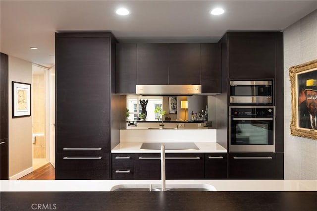 kitchen featuring stainless steel appliances, light countertops, a sink, and modern cabinets