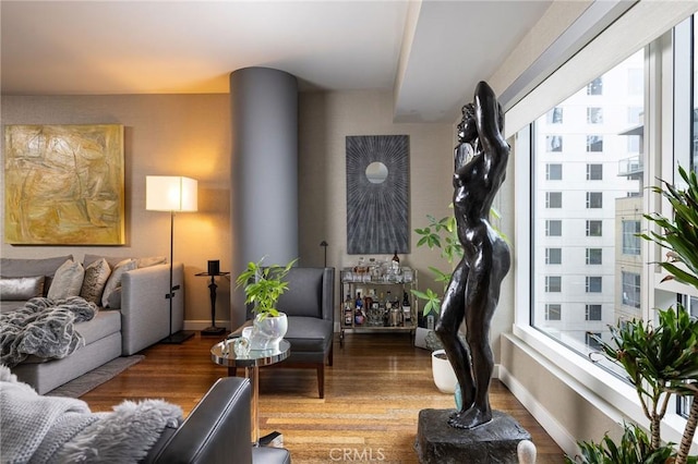 living room with plenty of natural light, wood finished floors, and baseboards