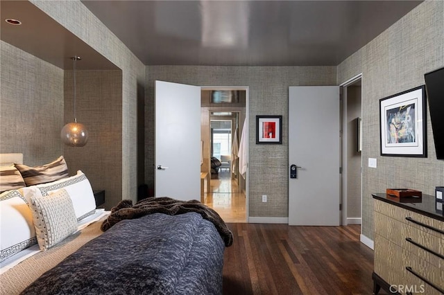 bedroom with baseboards and dark wood-style flooring