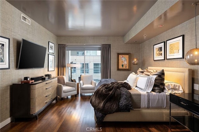 bedroom with dark wood-style floors, visible vents, baseboards, and wallpapered walls