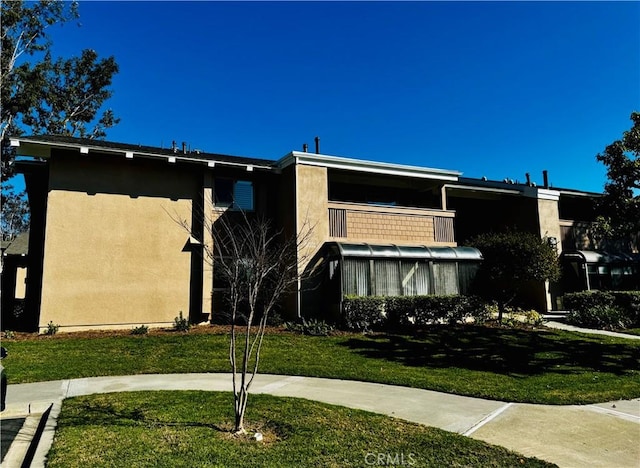 exterior space with a front yard and stucco siding