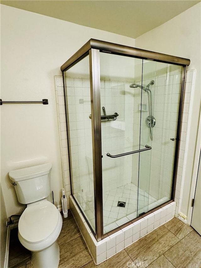 full bathroom featuring a shower stall and toilet