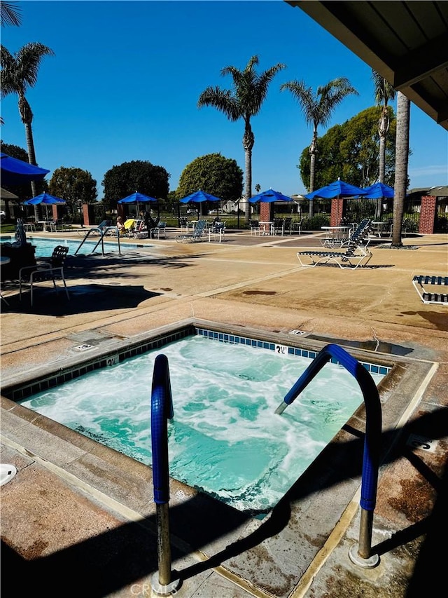 view of pool featuring a community hot tub and a patio area