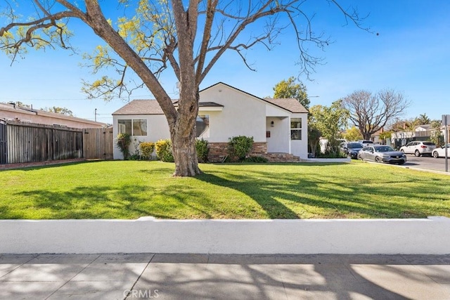 view of front facade featuring a front yard, fence, a residential view, and stucco siding