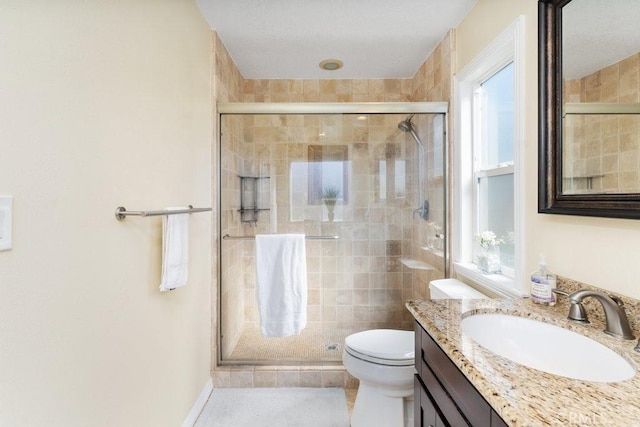 full bath featuring a stall shower, vanity, and toilet