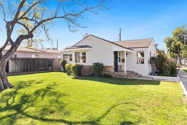 exterior space featuring stone siding, a chimney, fence, a front lawn, and stucco siding