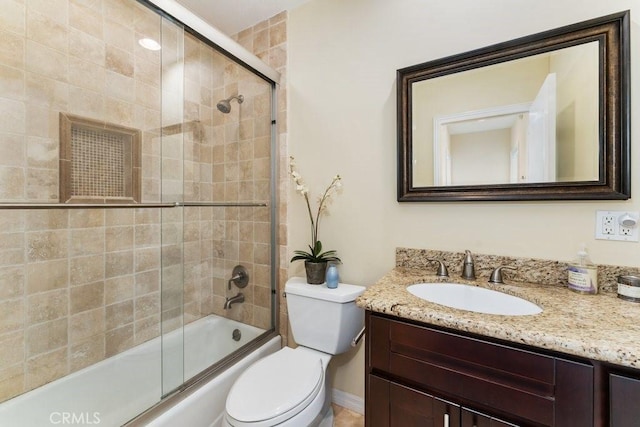 bathroom with toilet, combined bath / shower with glass door, and vanity