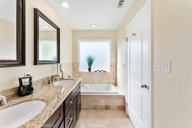 bathroom with a garden tub, a wealth of natural light, a sink, and visible vents