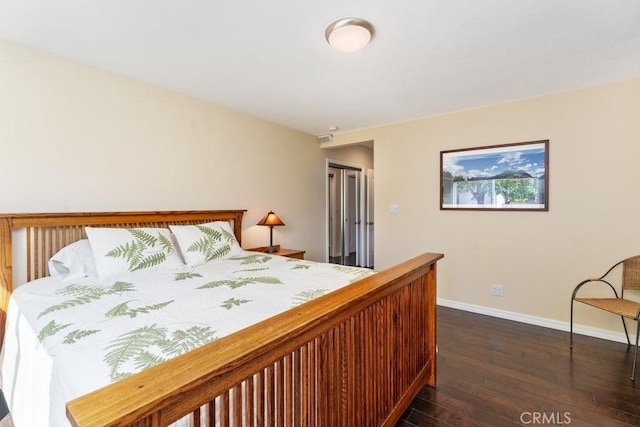 bedroom with dark wood-type flooring and baseboards