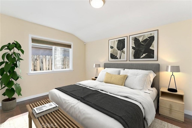 bedroom featuring vaulted ceiling, dark wood-style flooring, and baseboards