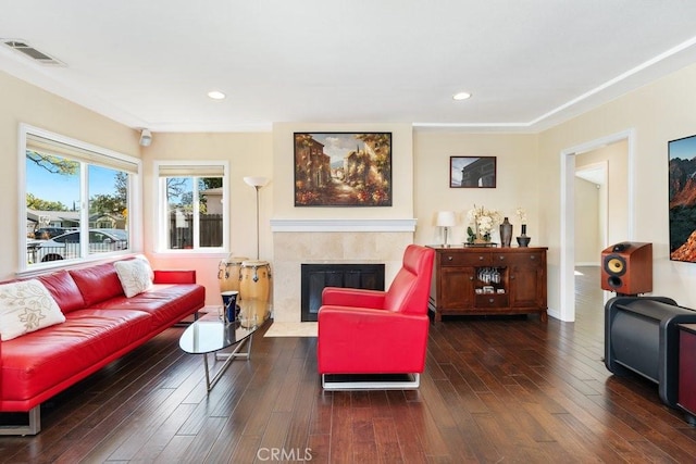 living area featuring dark wood-type flooring, a fireplace, visible vents, and recessed lighting