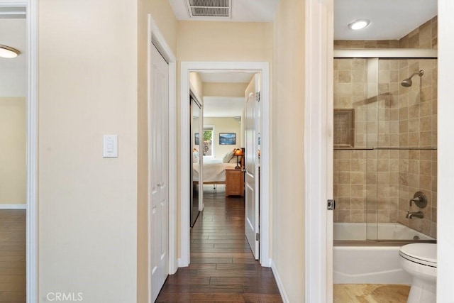 ensuite bathroom featuring visible vents, toilet, shower / bath combination with glass door, ensuite bath, and a closet