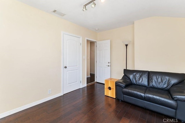 living area featuring visible vents, track lighting, baseboards, and dark wood-style flooring