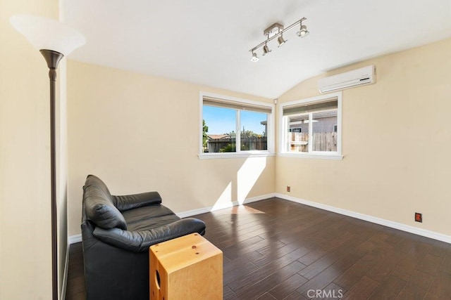 living area featuring lofted ceiling, dark wood-type flooring, baseboards, a wall mounted AC, and rail lighting