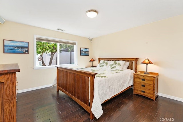 bedroom with baseboards, visible vents, and dark wood-type flooring