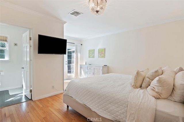 bedroom featuring light wood-style floors, visible vents, crown molding, and baseboards