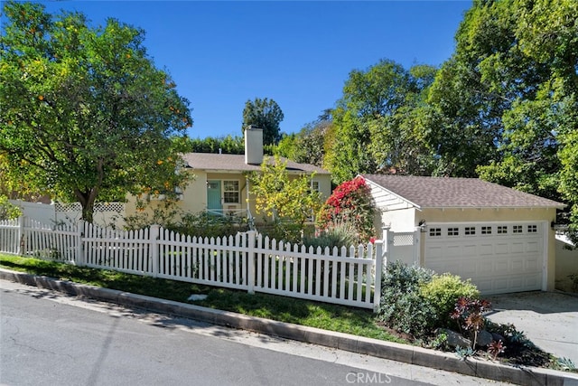 view of front of home featuring a fenced front yard, a garage, driveway, stucco siding, and a chimney